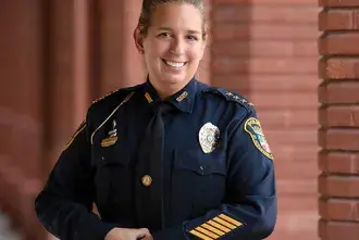 In uniform, Jennifer Michaux, Chief of Police for the city of St. Augustine, poses near the Ponce Hall pillars