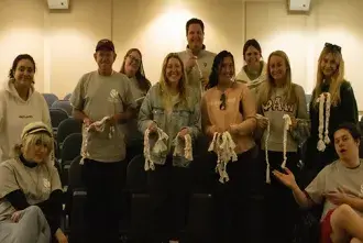 Students holding dog toys made for local shelter