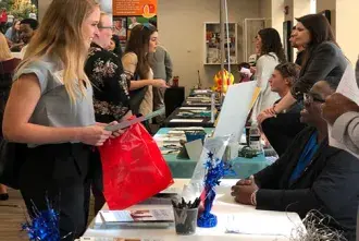 Student talking with employer at spring career expo