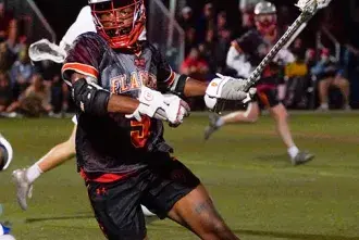 Lacrosse athlete, Ty Tom, on the field at inaugural lacrosse game. 