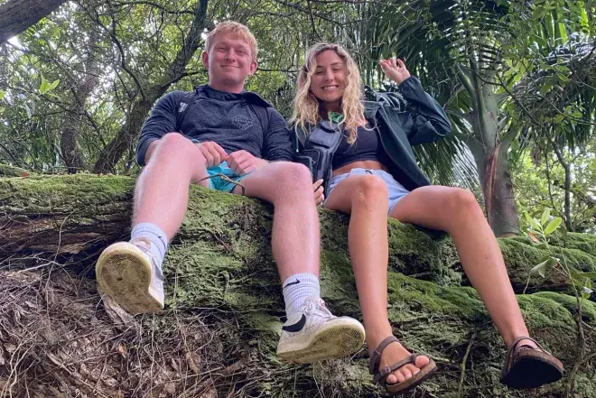Two Flagler College students sit on a tree.