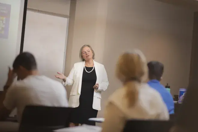 A faculty member is shown at a whiteboard.