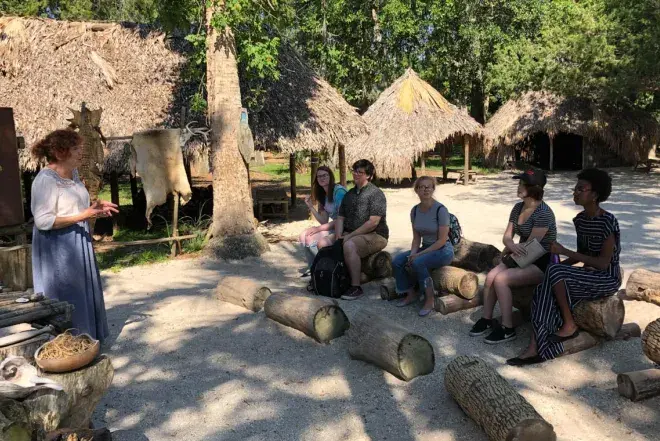 A Flagler College faculty member teaches a class outdoors.