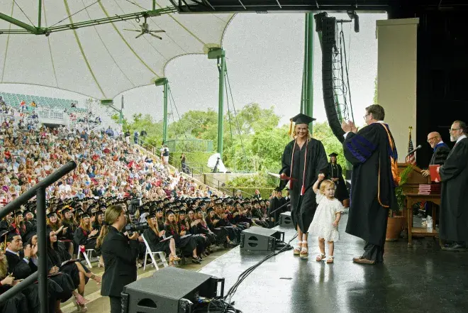 Madison Hope Taylor ('23) and daughter crossing  stage at Commencement