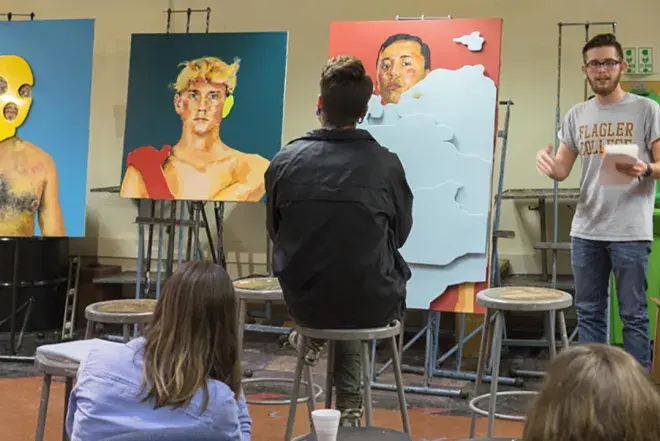 A Flagler College student contemplates artwork.