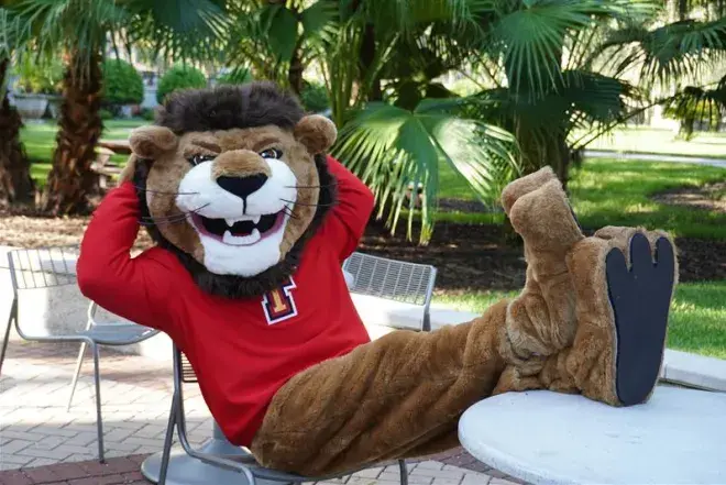 Leo the mascot lounging in a chair