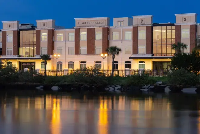 Abare Hall exterior at night with the waterfront in the foreground