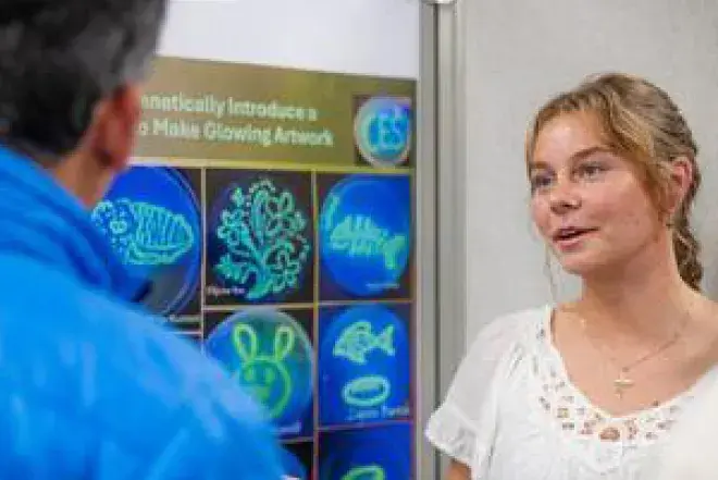 Photo of Student Showing Research Work to Person