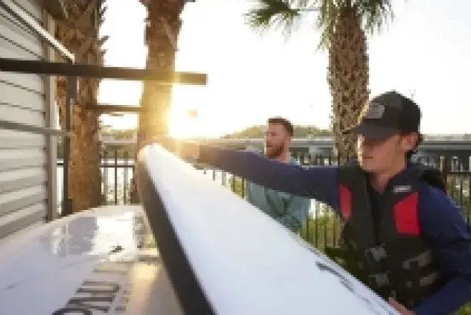 Students on dock grabbing kayaks