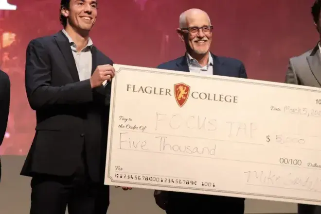 Students and professor holding donation check