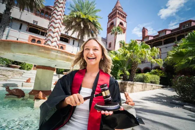 Student in cap and gown with gavel