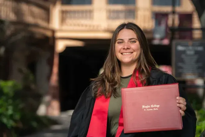 Student in cap and gown holding diploma