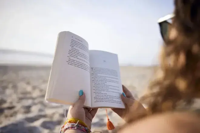 Person reading a book at the beach