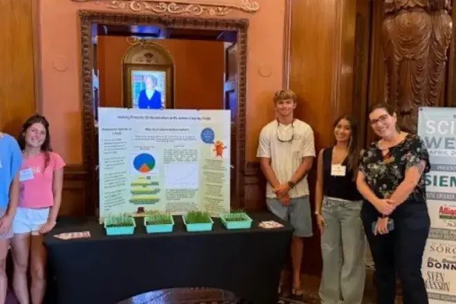 Students standing in front of Science Week presentation
