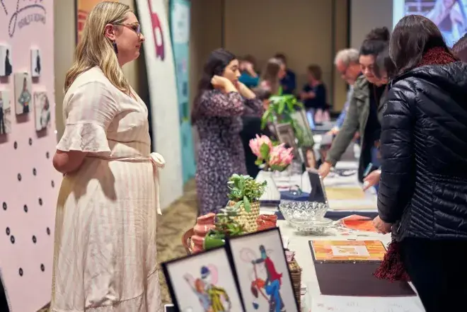 People browsing artwork at table