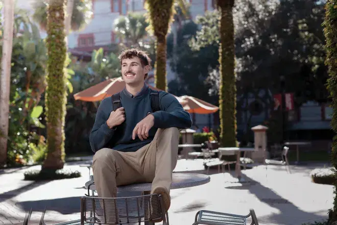 Environmental Science student Pasquale Arnone smiling and sitting on a table