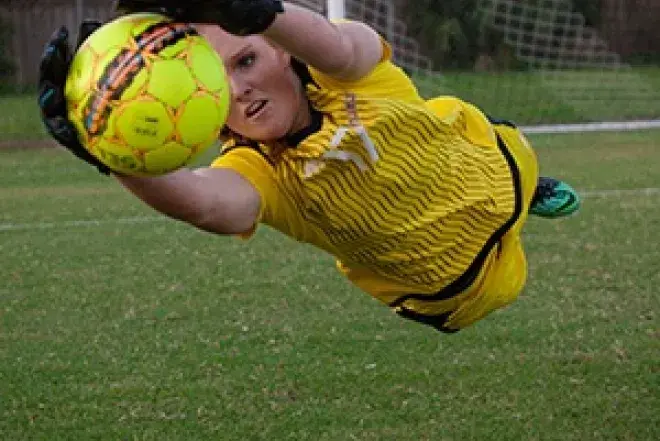 Woman diving for soccer ball.