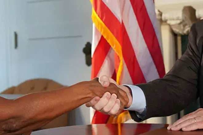 Flagler College President John Delaney shakes hands with Bermuda College's Phyllis Curtis-Tweed.