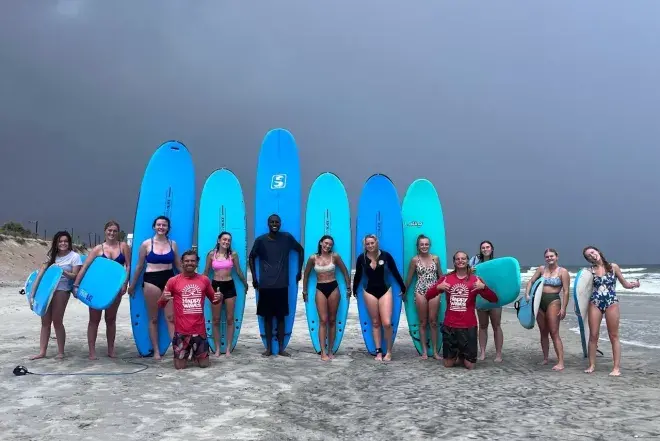 Surf Trip 3.jpg Students standing in front of surf boards