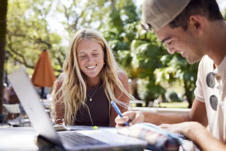 Two Flagler College students work on a project.