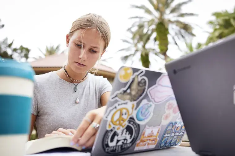 A Flagler College student reads intently.