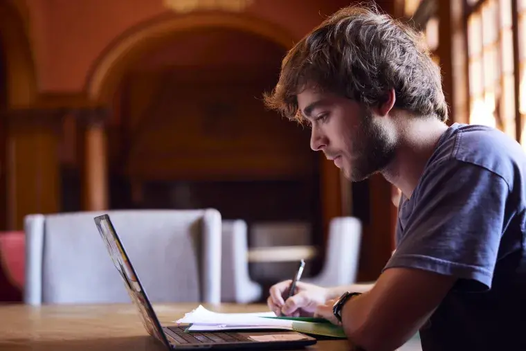 A Flagler College student studies a laptop.