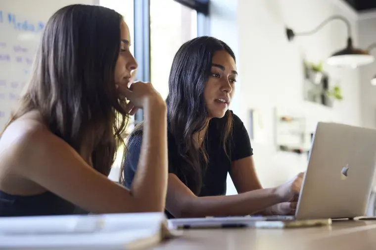 Two Flagler College students work on a project together.