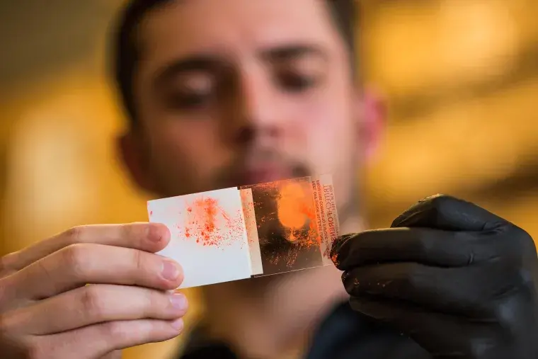 A student holds up an evidence slide.