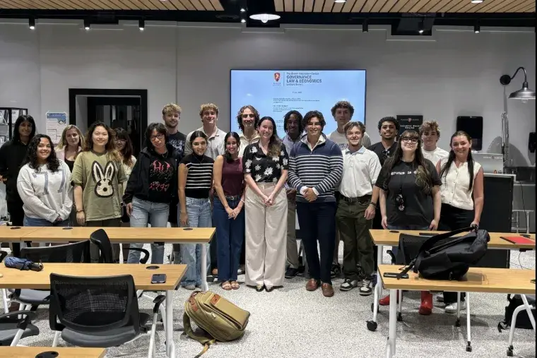 Flagler's Financial Investment Club stands at the front of a classroom for a picture