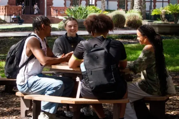 Photo of students sitting at table outside