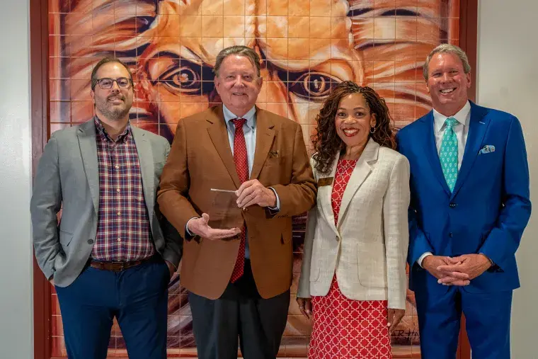 President John Delaney, Vice President & Chief Human Resources Officer Kelly Toaston, Compensation and Benefits Campus Partner Hayden George, and Trustee Mark Bailey Sr pose with the wellness award