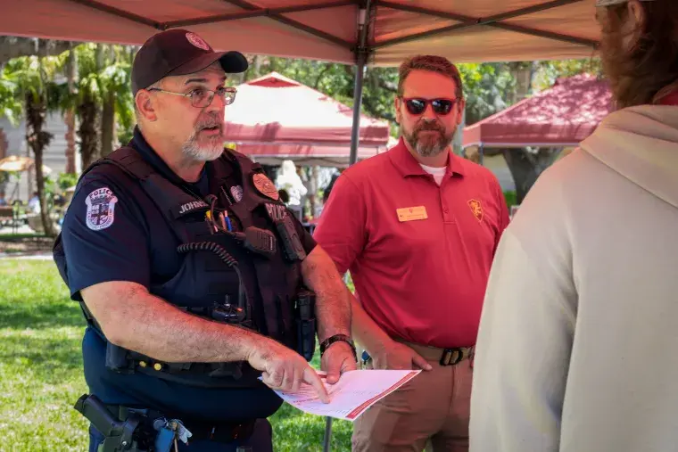 Officer Gary Johnson directs a student by pointing to a map