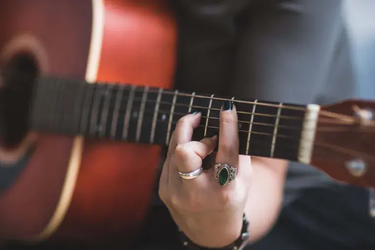 Lifelong Learning Courses in Art and Music: A woman playing a guitar 