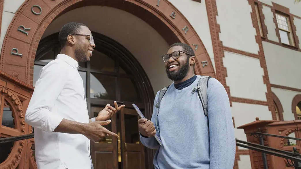 Faculty and student working together in front of the proctor library