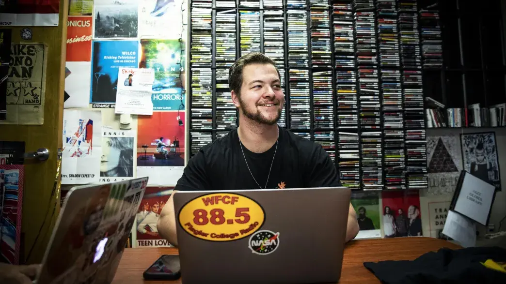 A Flagler College student works in the Flagler College radio station offices.