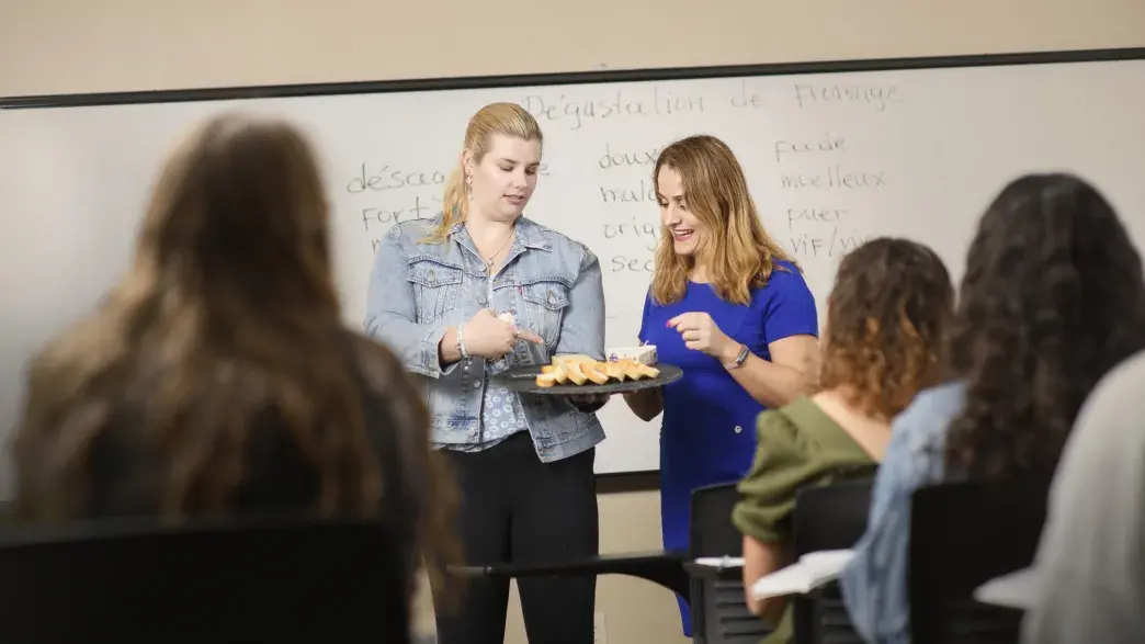 Flagler College students look at a tray of French food.