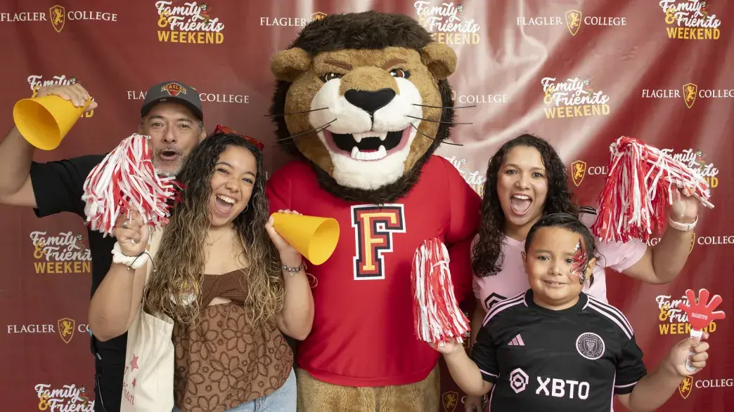 Flagler College mascot Lewis the Lion and students at the tailgate event.