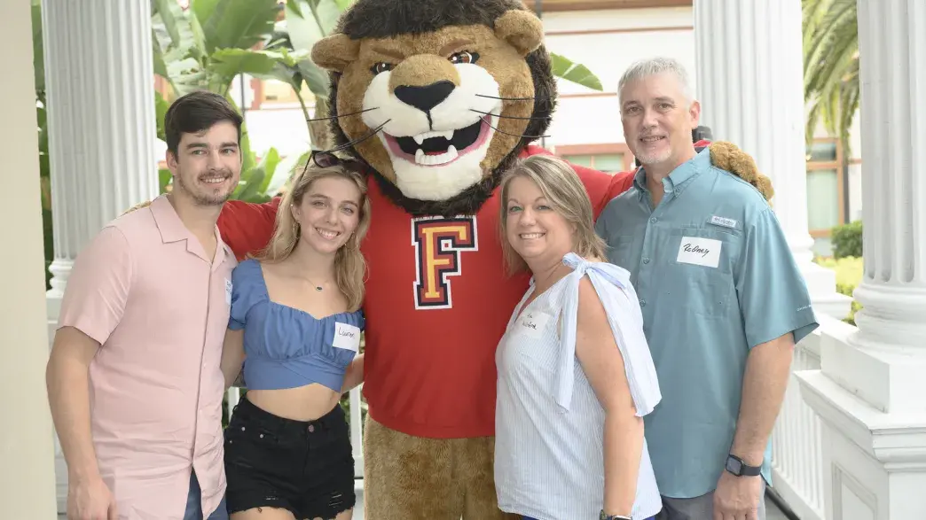 Flagler College mascot Lewis the Lion with a family.