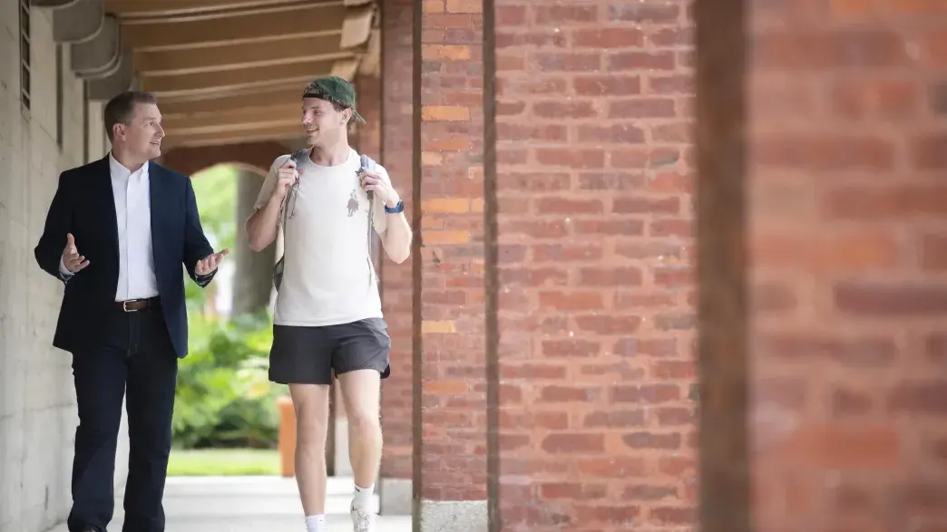 A faculty member walks with a student.
