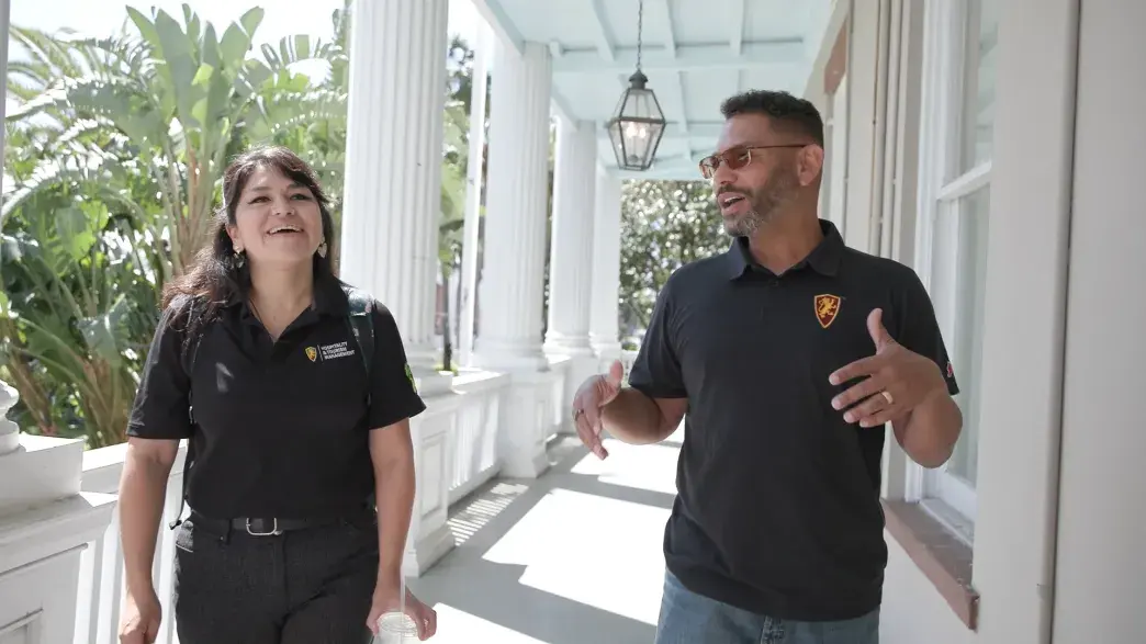 Rachael Castillo walking with a professor in front of Markland House