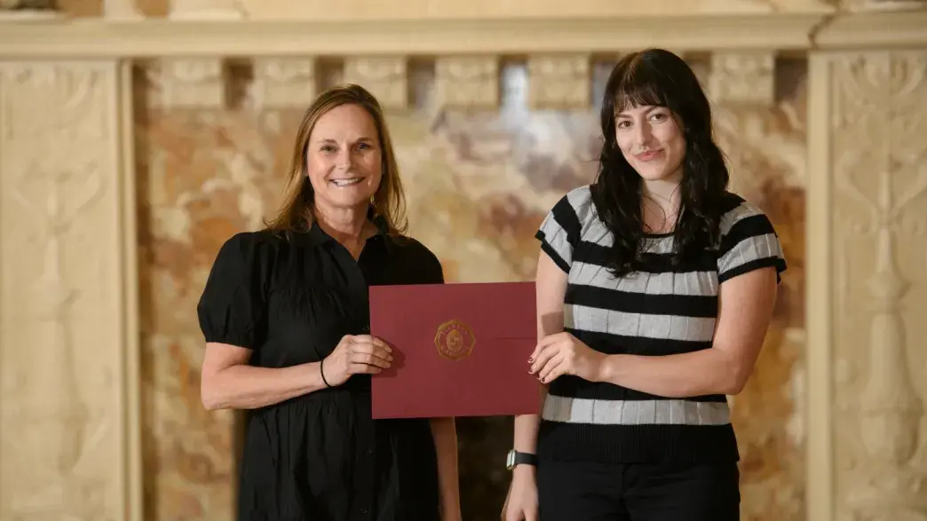 Photo of student and professor holding degree