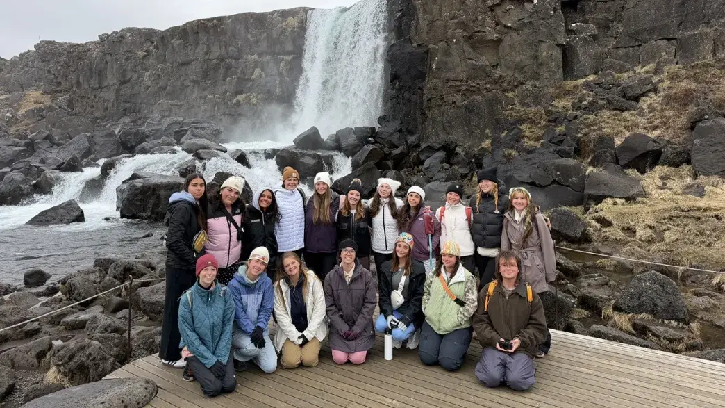 Students in group photo in front of waterfall