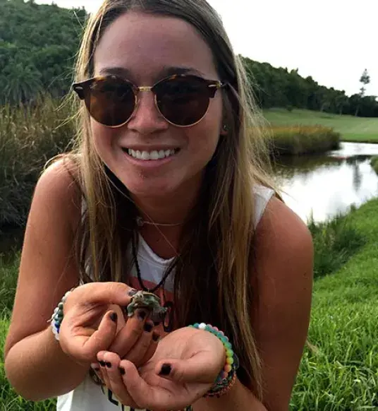 Student Chrissy Sevret holds small turtle