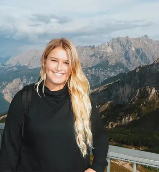 Student Katherine Malloy stands in front of mountains in background. 