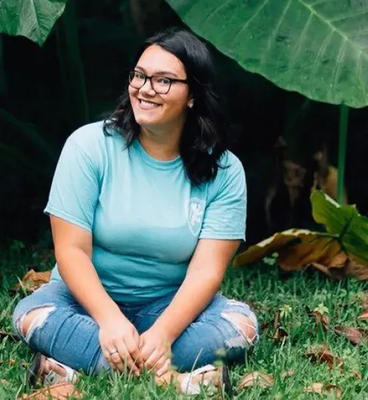 Student Sarah Espinosa sits outdoors. 