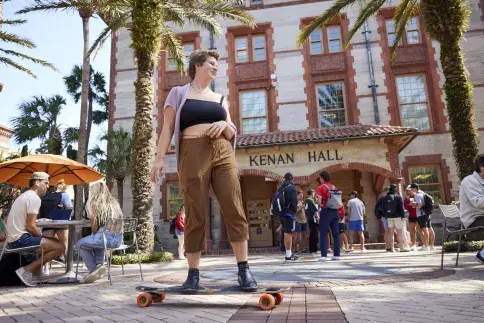 Student Riding Skateboard Outside Kenan Hall