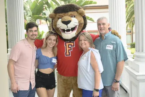 Flagler College mascot Lewis the Lion with a family.