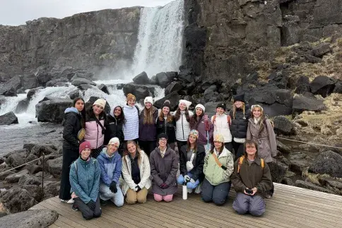 Students in group photo in front of waterfall