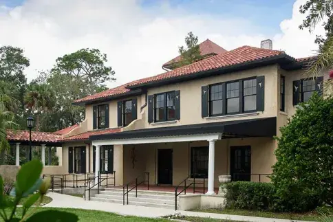 Alumni House viewed between foliage