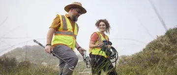 Dr. Ben Atkinson walking on the beach with a student